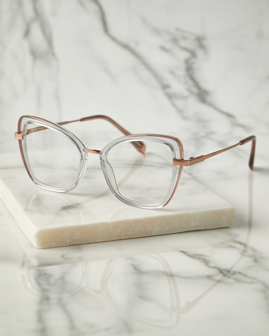 Transparent butterfly eyeglasses with rose gold accents on marble